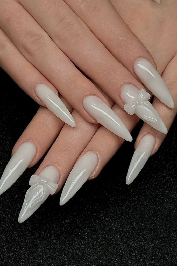Milky white glossy stiletto nails.