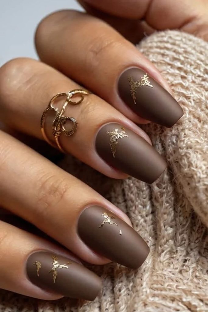 Mocha nails with delicate gold detailing.