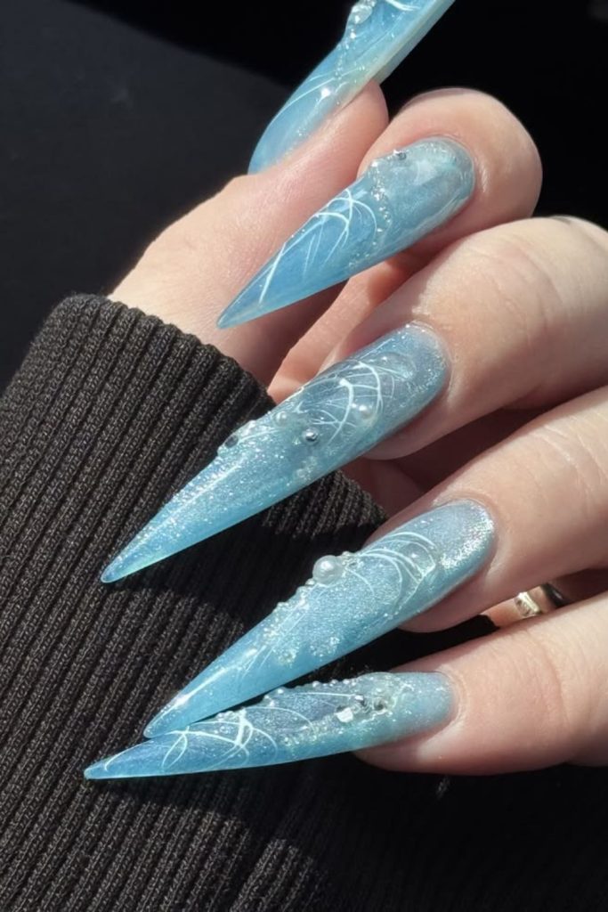 Pearlescent blue pearl stiletto nails.