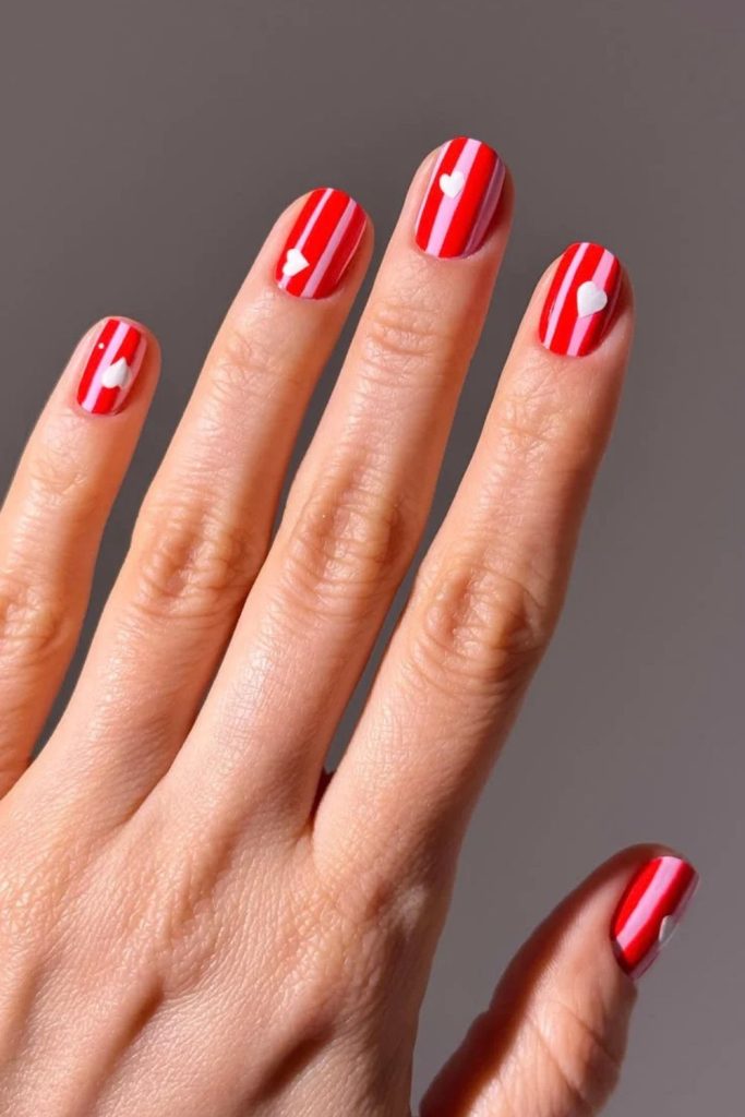 Sweet peppermint heart Christmas nail design.