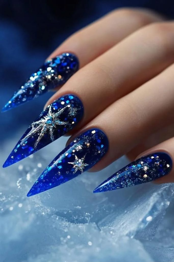 Sapphire blue galaxy stiletto nails.