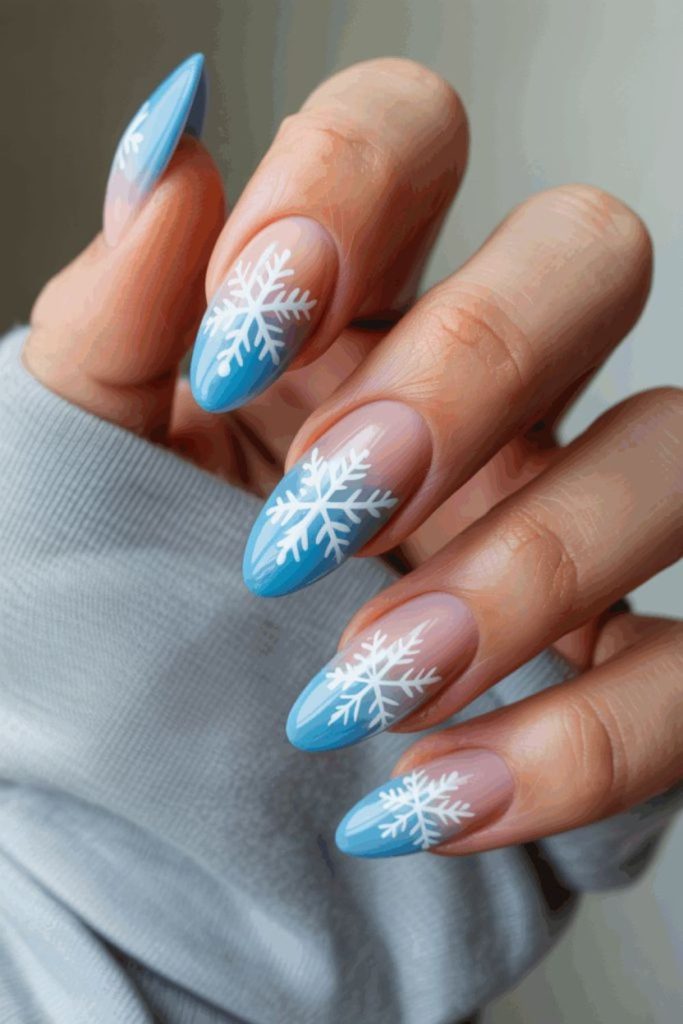 Pale blue ombré snowflake nails.