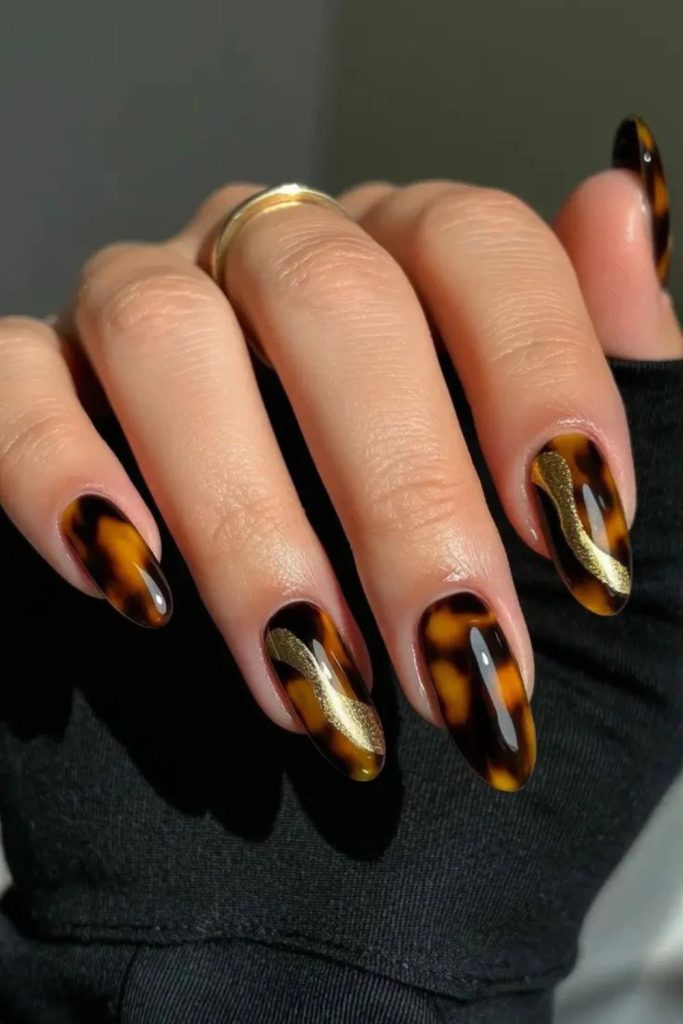 Chrome accented tortoiseshell manicure style.
