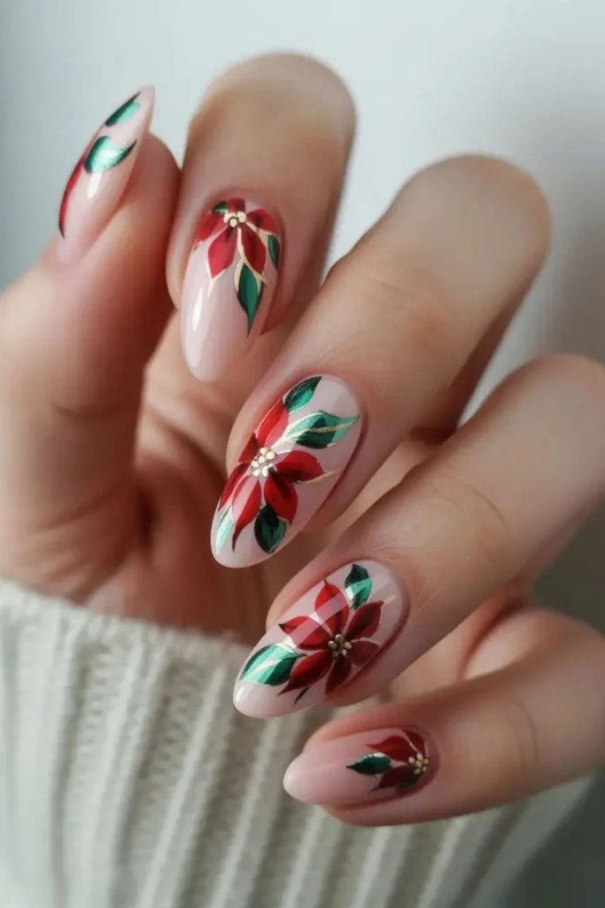Almond nails featuring elegant red poinsettia artwork.