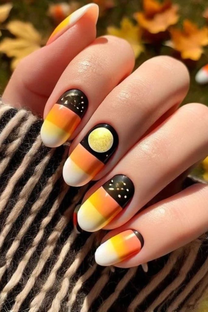 Black Halloween nails with candy corn accents.