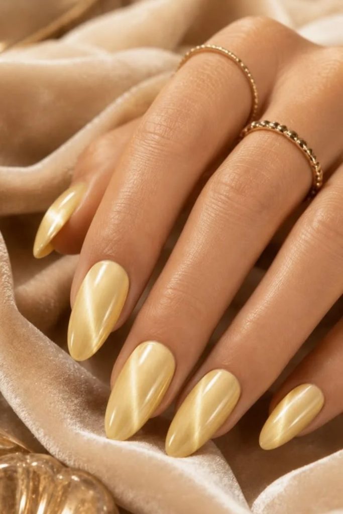 Butter yellow chrome almond nails.