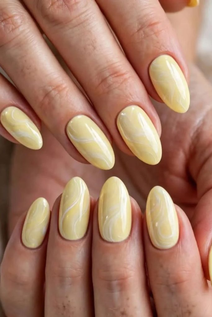 Butter yellow white swiggle nail art.