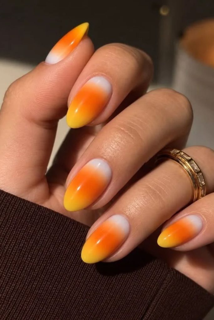 Glowing candy corn aura Halloween nail designs.