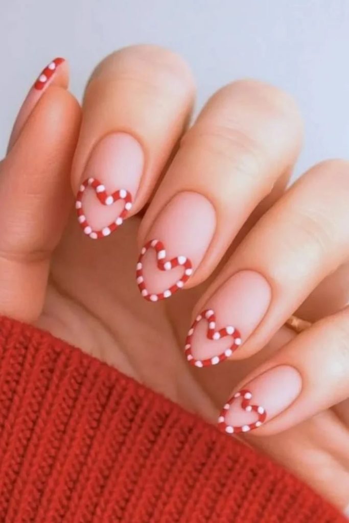 Candy corn nails decorated with tiny hearts.