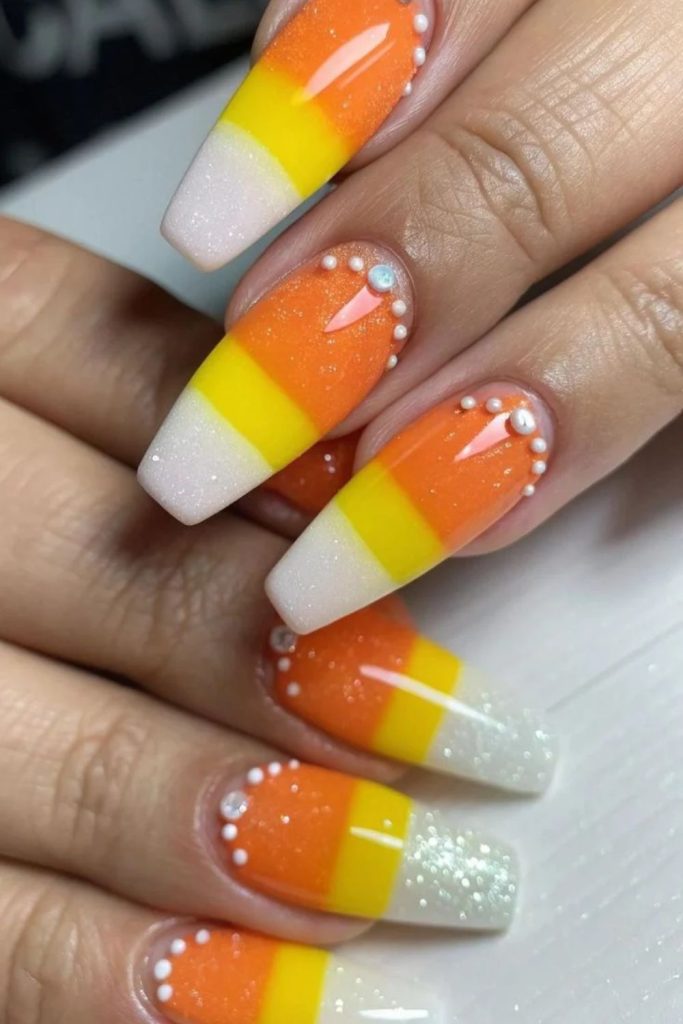 Candy corn nails decorated with sparkling rhinestones.