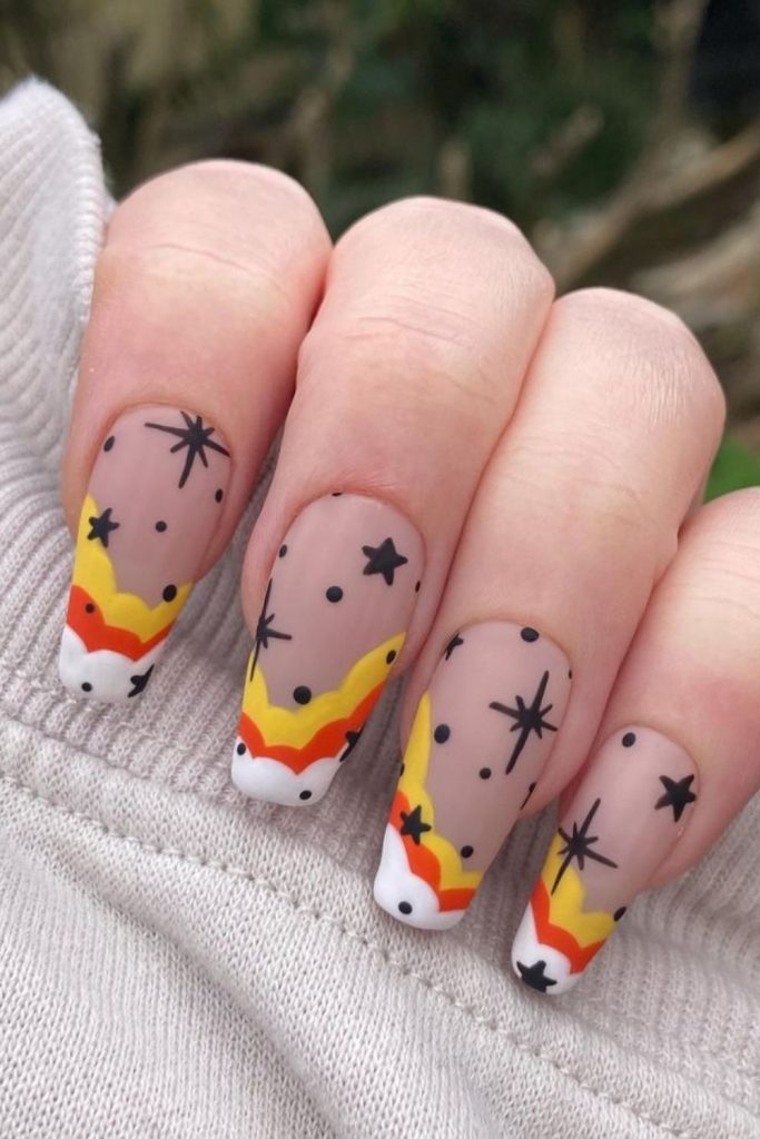 Candy corn nails with tiny starry details.