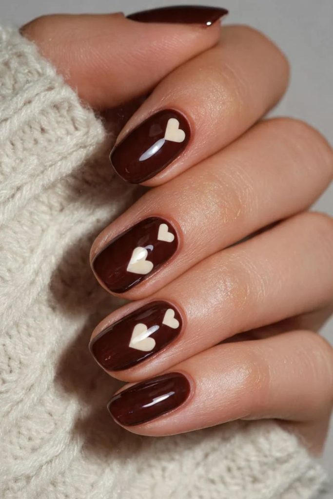 Cherry mocha nails with tiny hearts.
