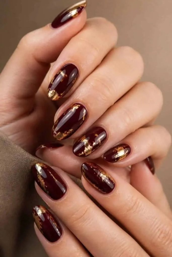 Cherry mocha nails with gold foil.