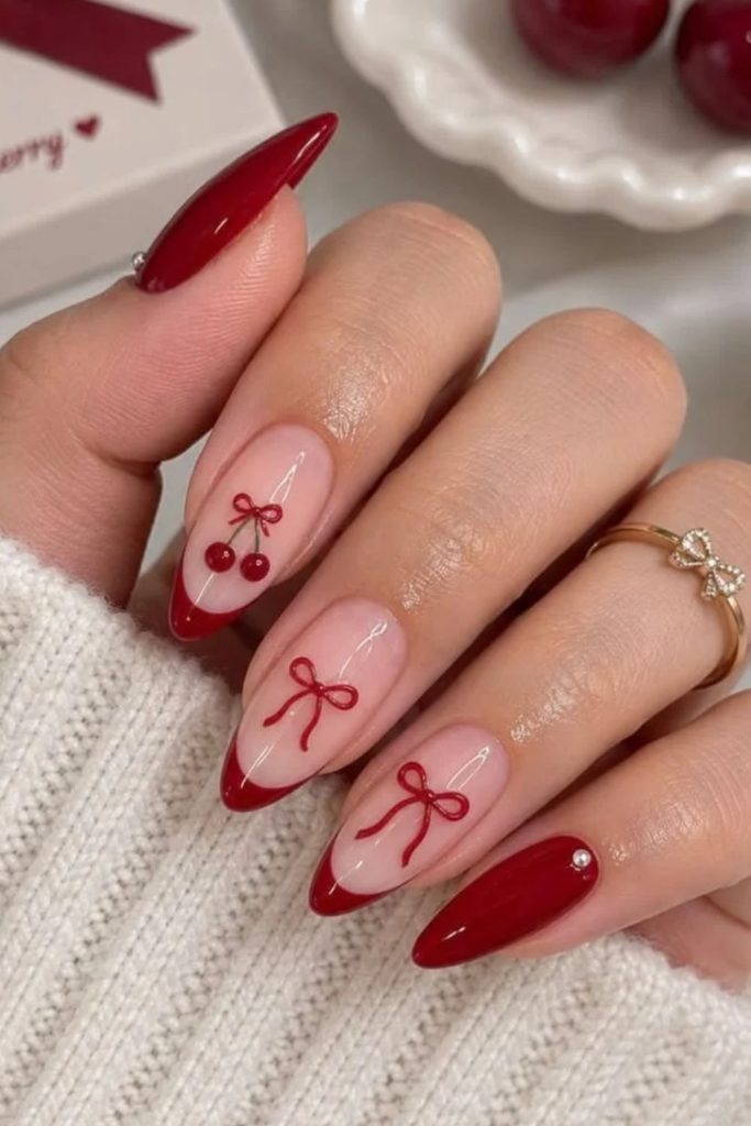 Cherry red coquette nails with playful details.