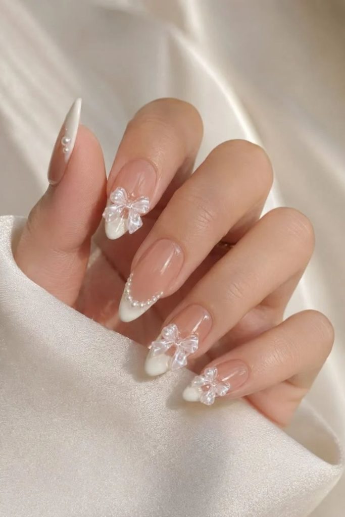 French tip coquette nails with tiny bows.