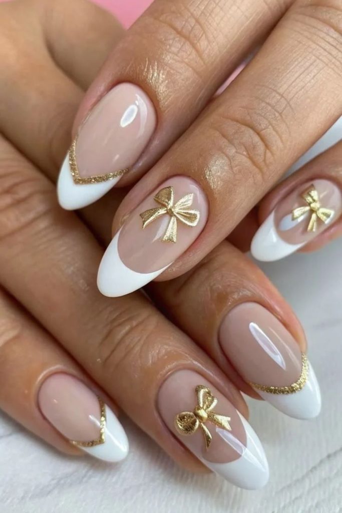 Gold bow coquette nails with pink polish.