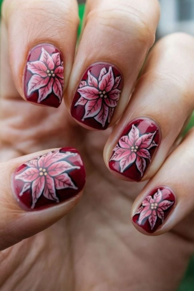 Deep plum nails with burgundy poinsettia flowers.