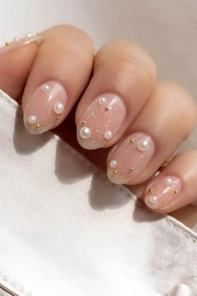 Pearl disco nails with elegant metallic embellishments.