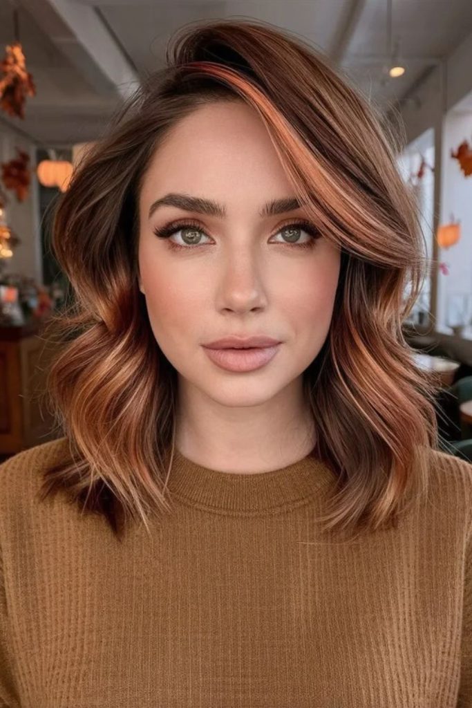 Hazelnut brown hair with peekaboo highlights.