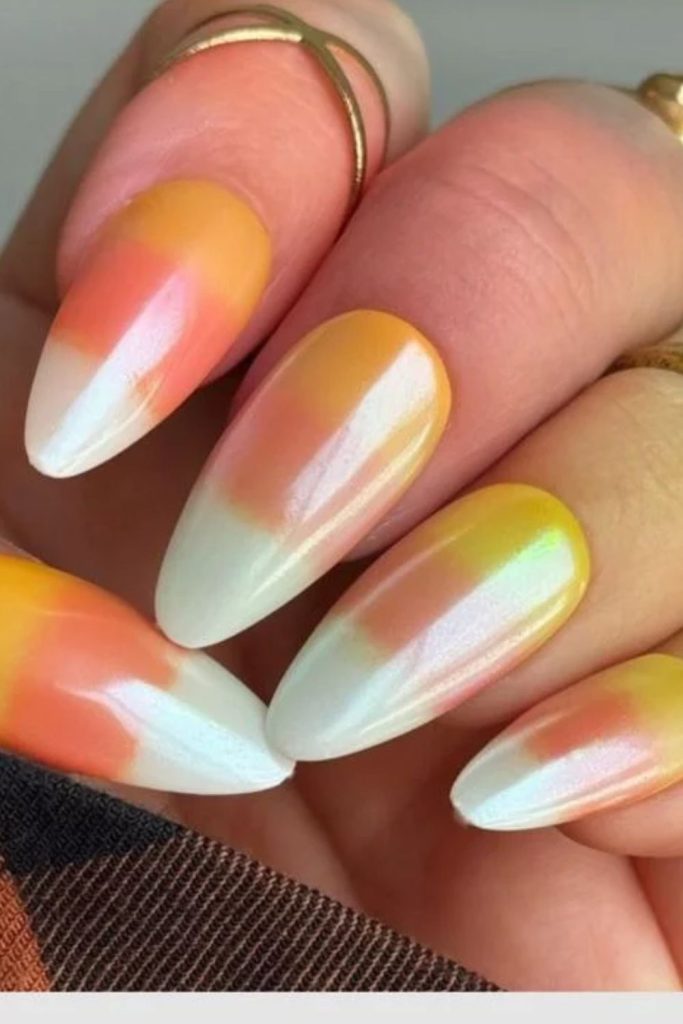 Holographic candy corn nails with rainbow shimmer.