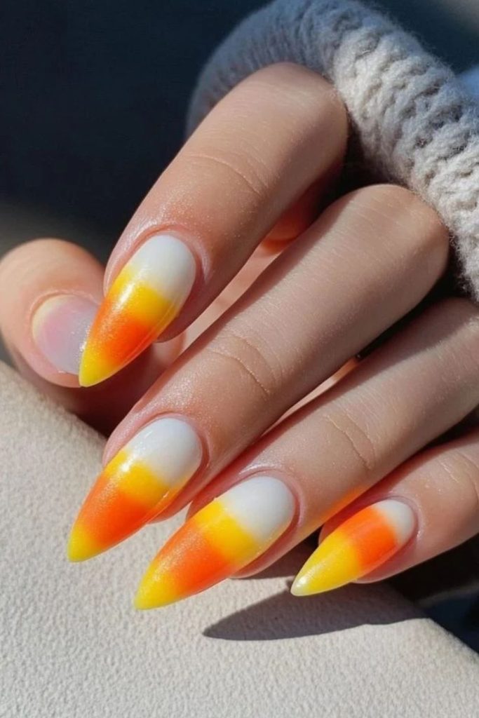Long almond nails with candy corn stripes.