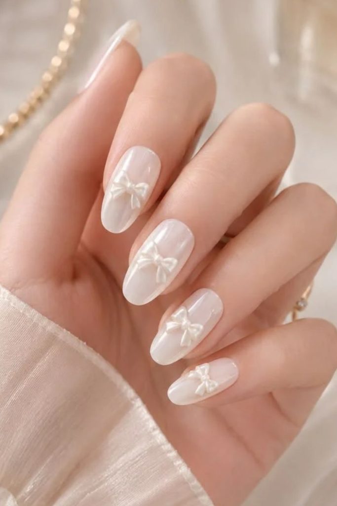 Milky white coquette nails with subtle bows.