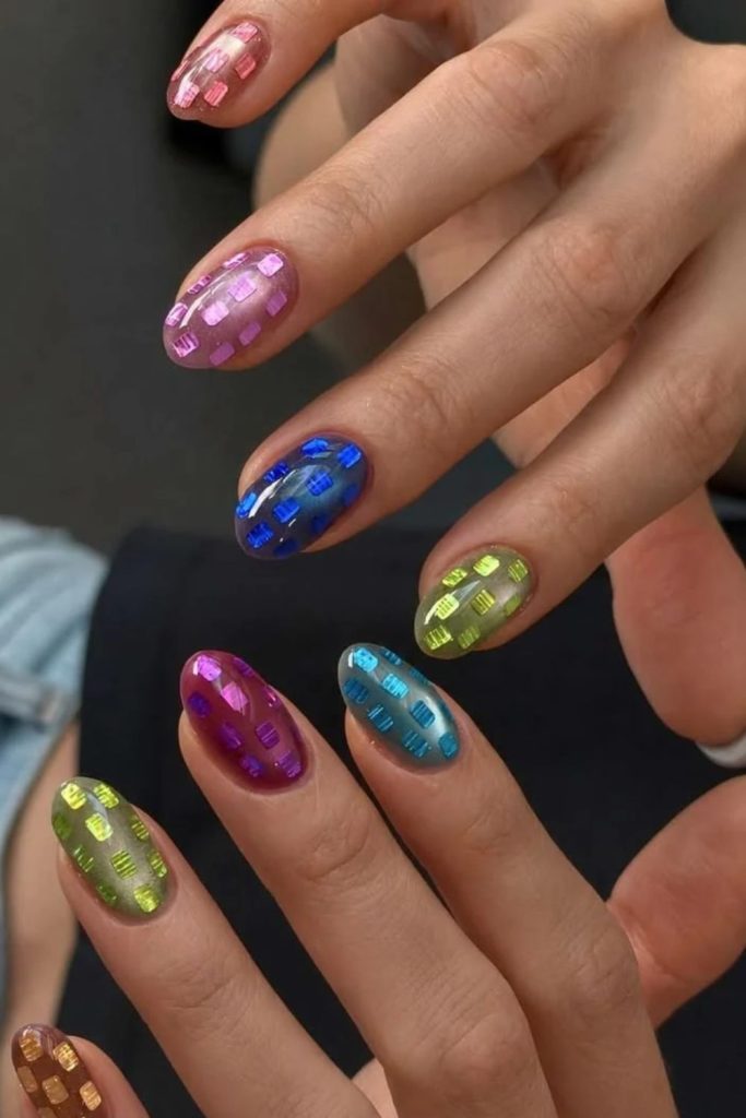 Neon disco nails with vibrant reflective decorations.
