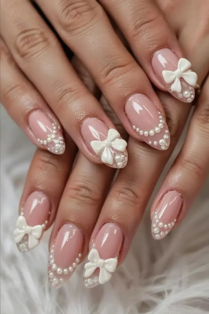 Nude coquette nails with minimalist white bows.