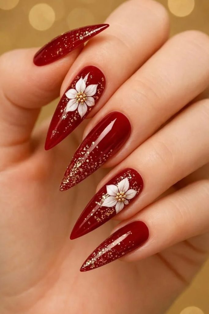 Shiny red chrome nails with poinsettia flowers.