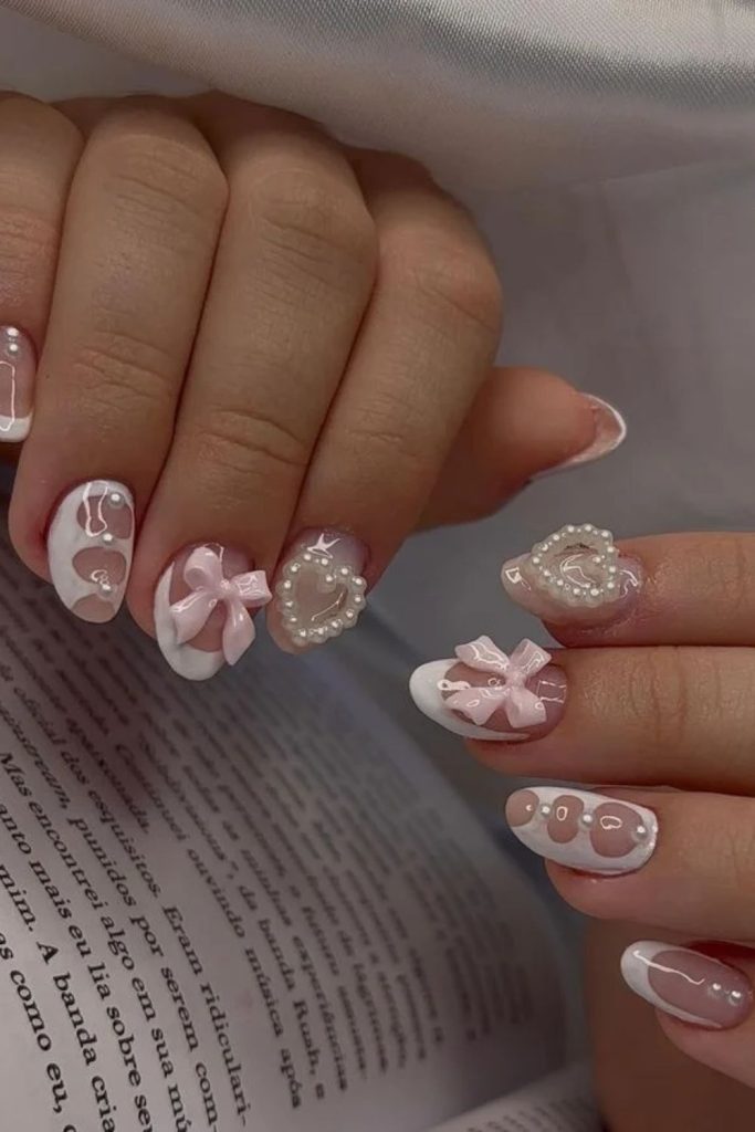 Short coquette nails with tiny pink bows.